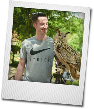 Junger Mann mit Eule auf dem Arm